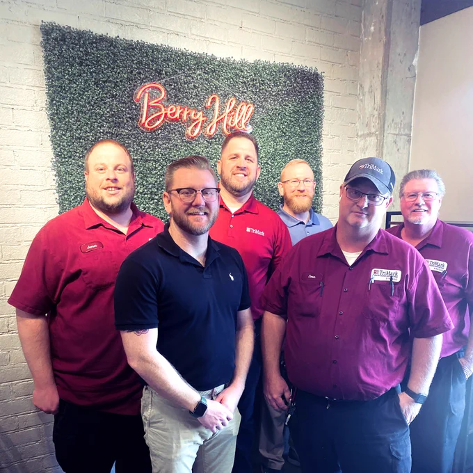 A group of individuals in red TriMark shirts