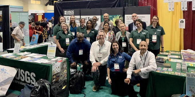 Group of USGS scientists and support staff pose in front of their booth at the SACNAS Conference in Puerto Rico.