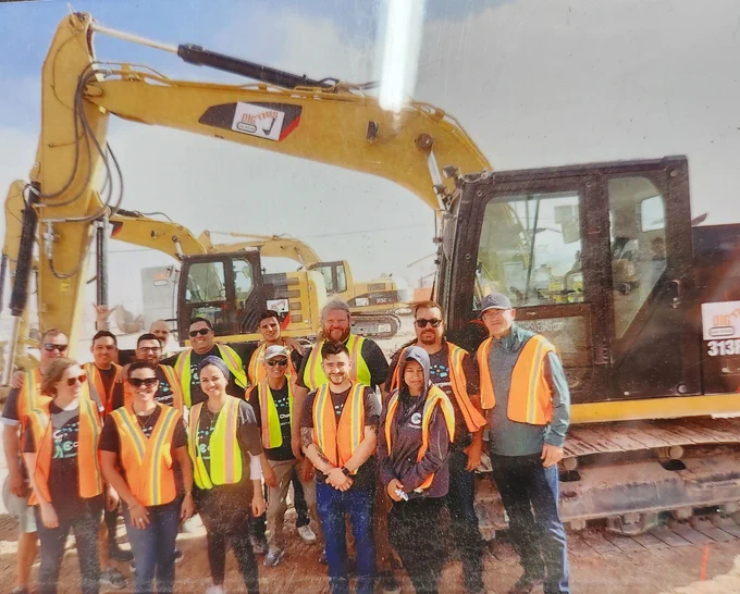 Chargent team together in front of diggers and bulldozers