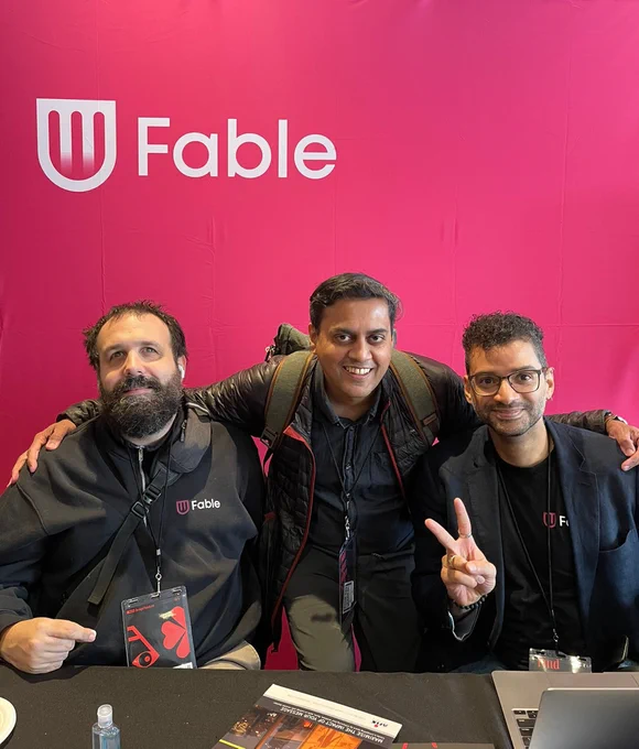 Sam Proulx, Frank Ferrao, and Huey Coelho pose in front of Fable's exhibit booth backdrop at RGD's Design Thinkers Toronto conference.