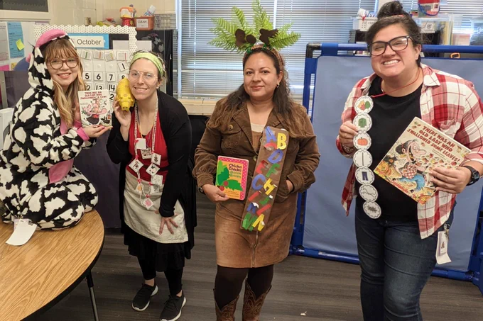 Pic of 4 teachers dressed up as different characters. From left to right: a cow, Old Lady who Swallowed a Cow, Chicka Chicka Boom Boom, and Old Lady who Swallowed some Leaves.