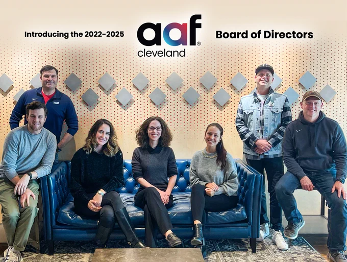 Seven American Advertising Federation-Cleveland directors sit on and around a blue couch.