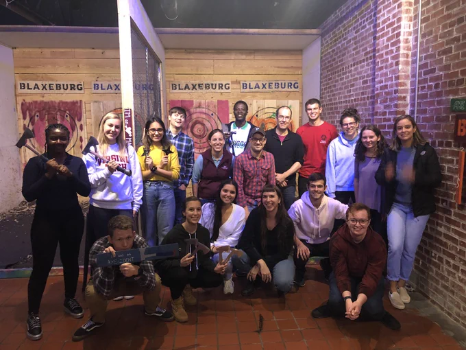 Members of the Lowell and mevers lab celebrating axe throwing in front of the lane