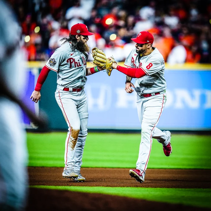 Nick Castellanos and Brandon Marsh tapping their gloves after Castellanos made a ridiculous catch (again, are you kidding) to keep the game tied. They're wearing the grey Phillies uniform.