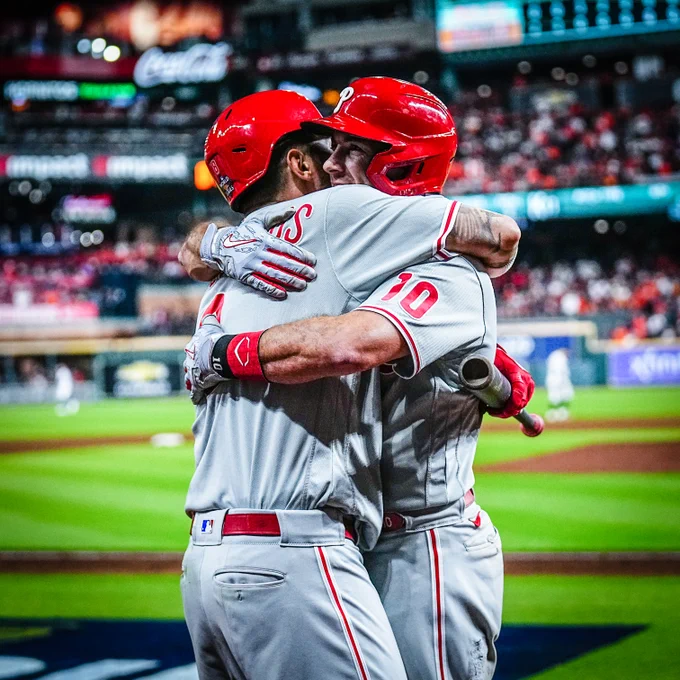 J.T. Realmuto and Nick Castellanos hugging each other after Realmuto hits the game-winning home run. They both deserve a hug. They're wearing the grey Phillies uniform.