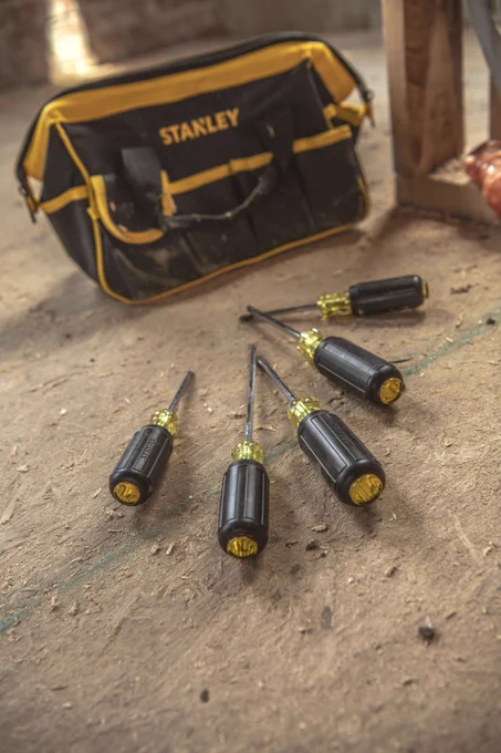 A STANLEY® Tool Bag sitting next to the 6 pc. Vinyl Grip Screwdriver Set on a plywood flooring. 