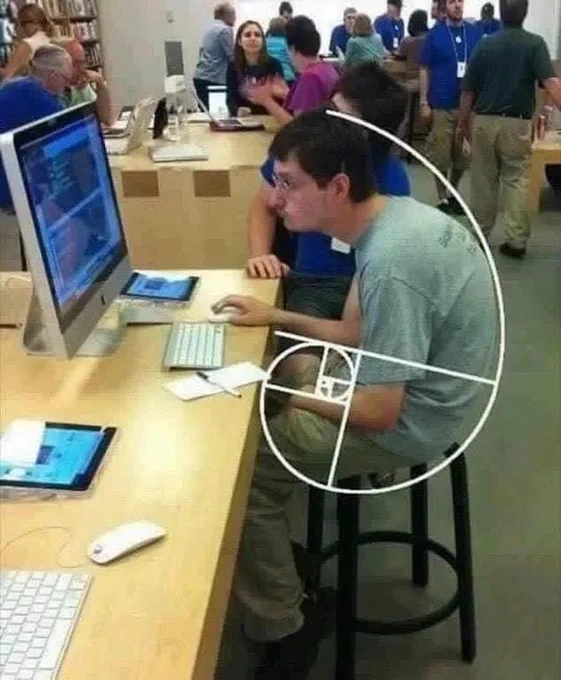 Geeky kid sitting with hunched back and slumped shoulders in front of a computer, with a perfectly-aligned Fibonnacci spiral superimposed