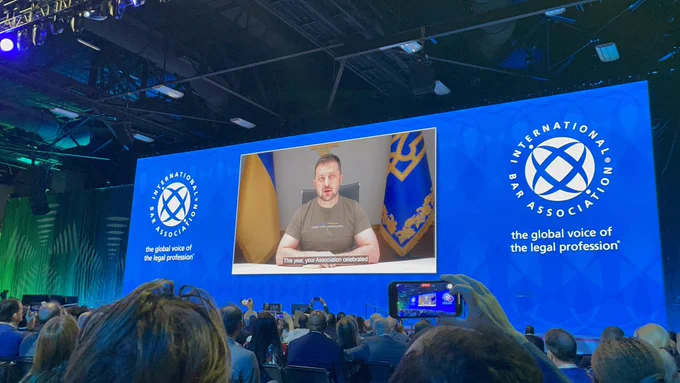 President Selensky speaking via video to the attendees of IBA conference.