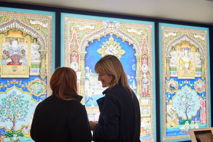 Two people looking at and enjoying exhibition content at Norwich Castle Museum and Art Gallery