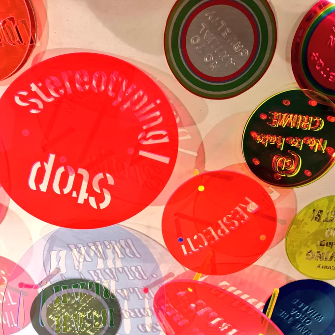 acrylic  discs in broght colours with protest messages 