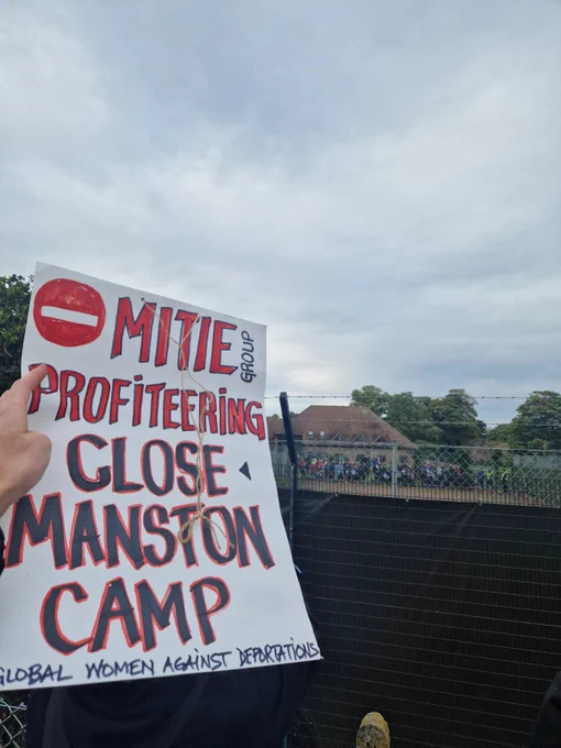 placard reading Mitie profiteering - close down manston camp