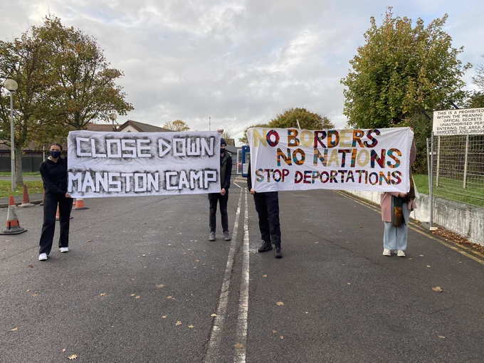Banners reading close down manston camp@and no borders no nations stop deportations