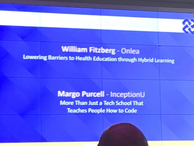 A picture showing a projected slide with the two finalist in the category of Innovative Approaches for Learning: William Fritzberg from Onlea, and Margo Purcell from InceptionU
