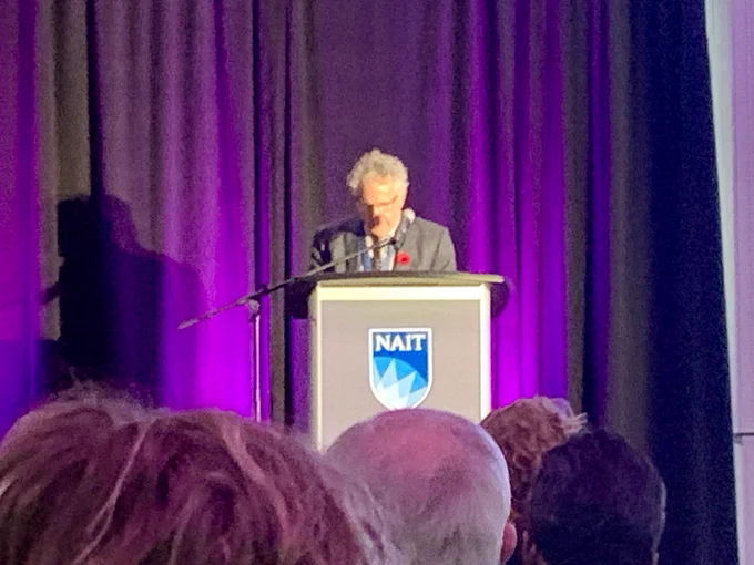 A picture of Dr. Jonathan Schaeffer on a podium giving a speech after receiving the ASTech award.