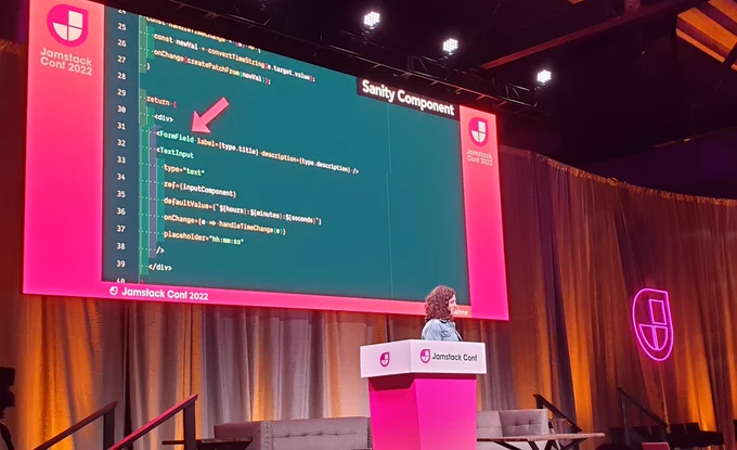 Amy Dutton on stage with a huge slide behind her with Sanity code example.