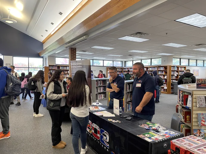 Students talking with local business at a fair. 