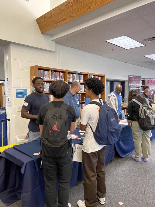 Students talking with local business at a fair. 