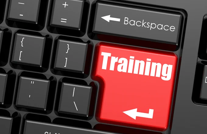 Close up view of a computer keyboard with a red key that says 'training'