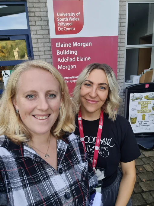 An image of Rhiannon Richardson and Emma Hughes standing outside the Elaine Morgan Building.