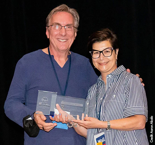 Photo of Christopher Wright accepting Viktor Hamburger Outstanding Educator Prize from Society for Developmental Professional Development and Education Committee Chair, Nicole Theodosiou.