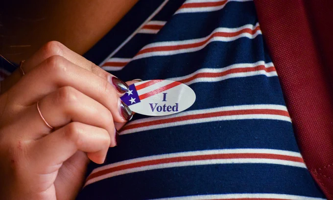 A person dons an “I Voted” sticker.