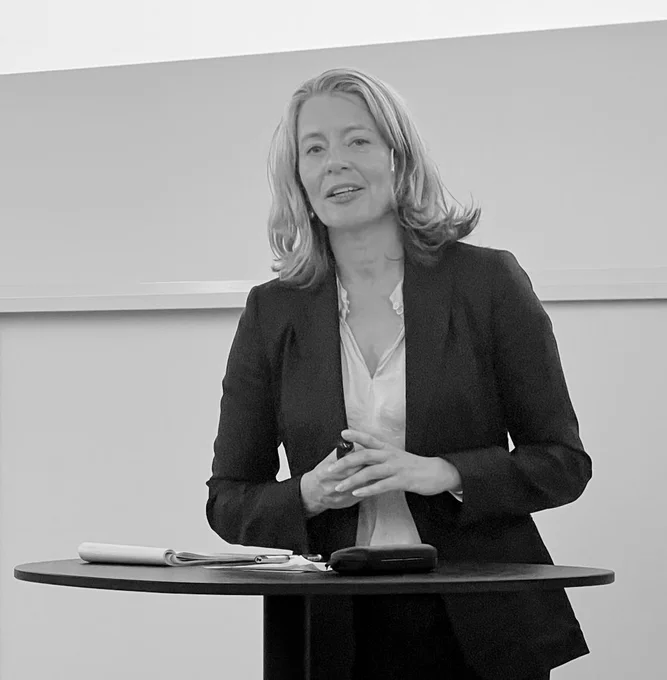 Kathrine Myhre ser i kamera mens hun presenterer