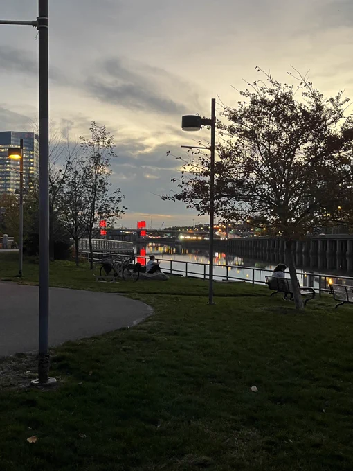 Schuylkill river banks in Philadelphia, bike path next to the river at sunset, with the south street bridge lit up red for the Phillies in the World Series