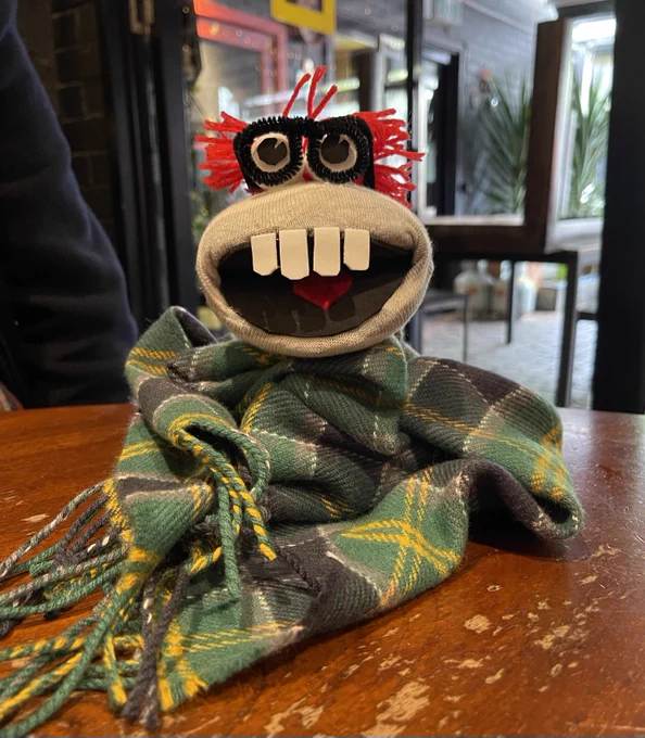 A sock puppet archivist in tartan scarf 