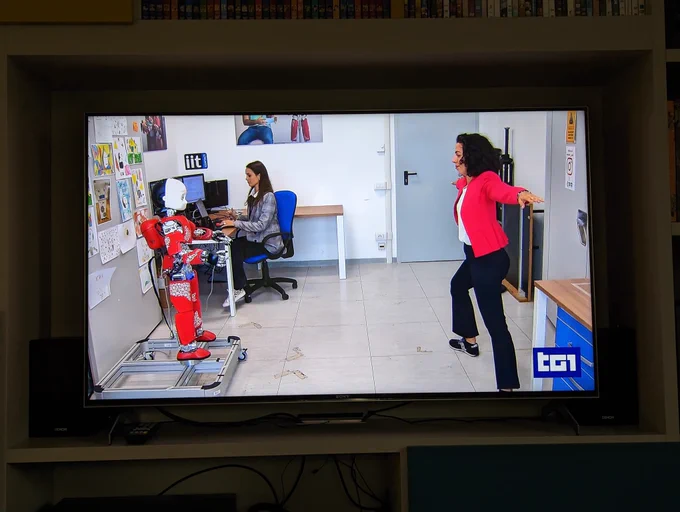 A picture of a demonstration of the robot iCub teaching a yoga pause to a student