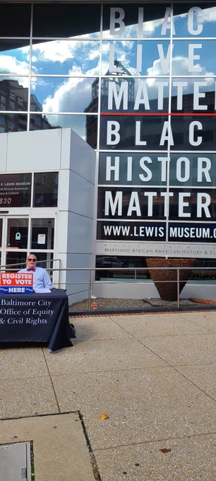 James Peyton sitting at a voter registration table outside the Reginald Lewis Museum