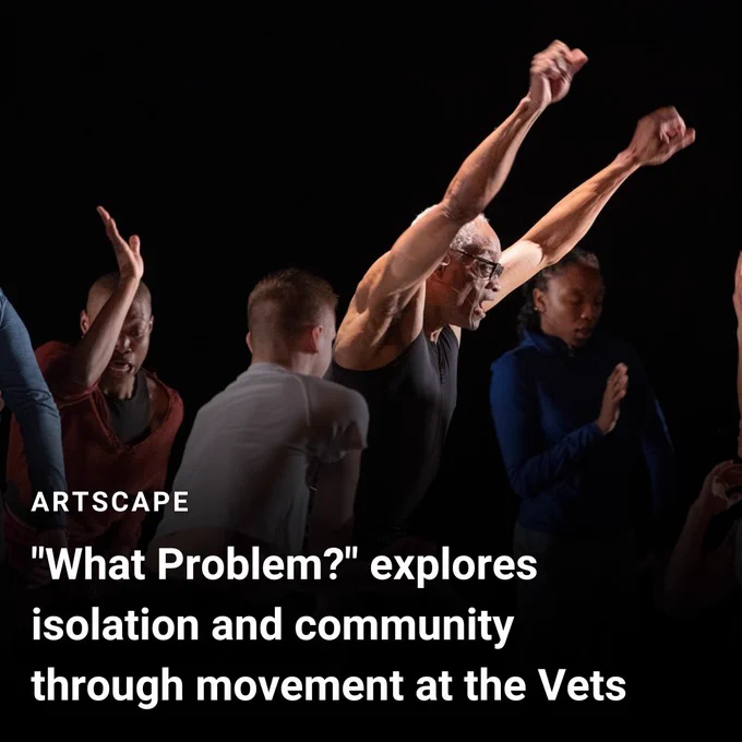 A black man stands in the center of the image with his arms raised. A spotlight is shining on him. He is dancing and is surrounded by other dancers. Text in the bottom left reads "Artscape: "What Problem?" explores isolation and community through movement at the Vets"