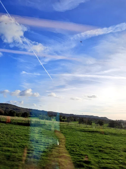 Green fields and blue sky. Photo from train window