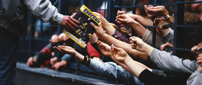 Matchday prgorammes being shared by football supporters
