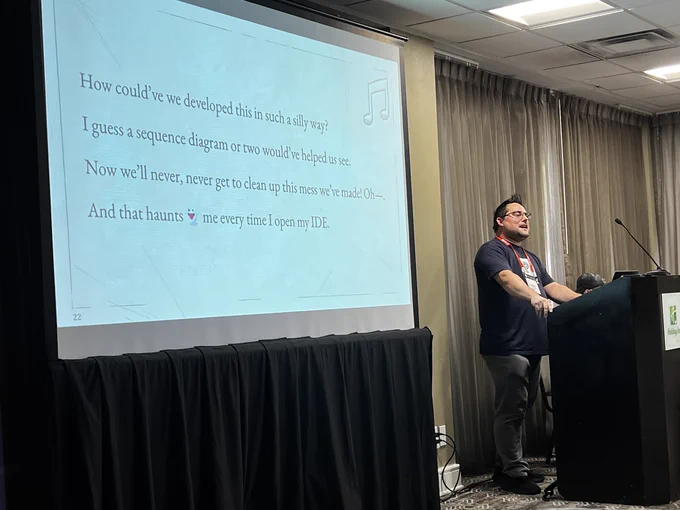 Jeremy singing at the podium with the song lyrics slide displayed beside him