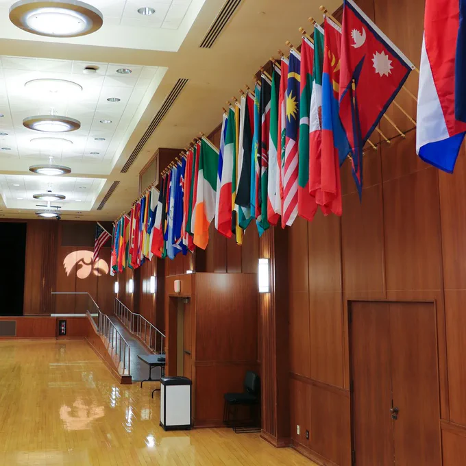 [ID. Photo of the newly installed, permanent display of flags in the International Ballroom that represent the international students and scholars that attend the University of Iowa. End ID]