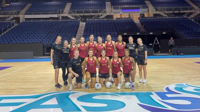 The Vitality Roses' Fast5 squad and Performance staff pose as a group on court in Christchurch