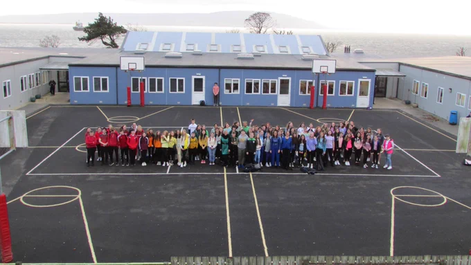 A large group of students wearing colourful clothes.  