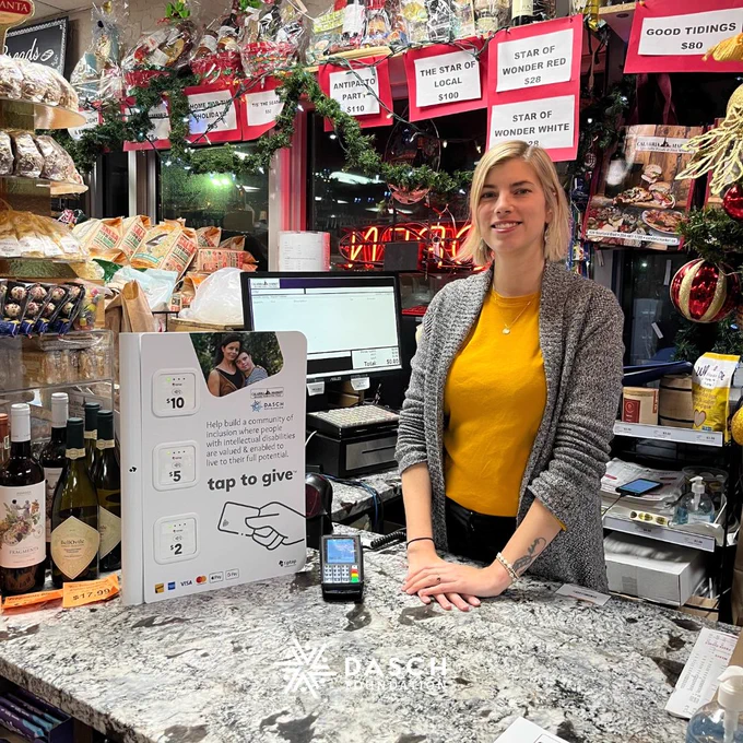 Calabria staff member stand beside the DASCH Foundation's tiptap machine.