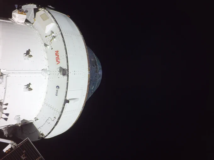 In this Orion "selfie," the Orion spacecraft is viewed beneath the base of the cone-shaped behicle. The white cylinder-shaped European Service Module can be seen against the blackness of space. 