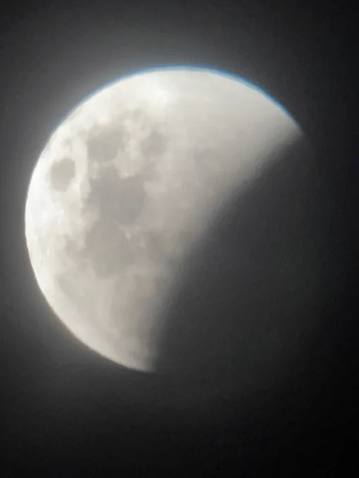 Rotated photo of the moon partially in shadow