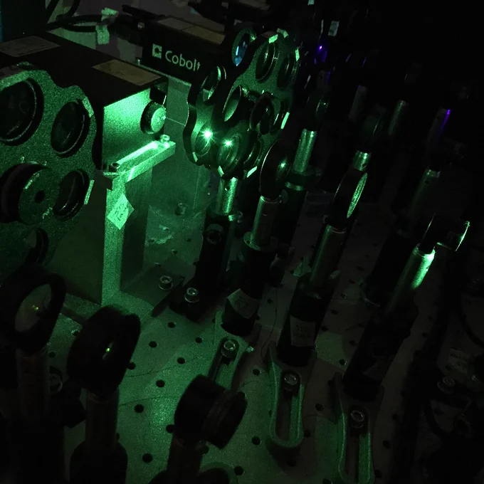 Green laser passing through optics. 