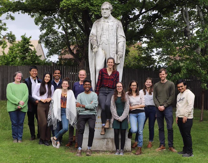 Members of the Edinburgh Single-Molecule Biophysics Group posing in front of the James Brewster Statue. 