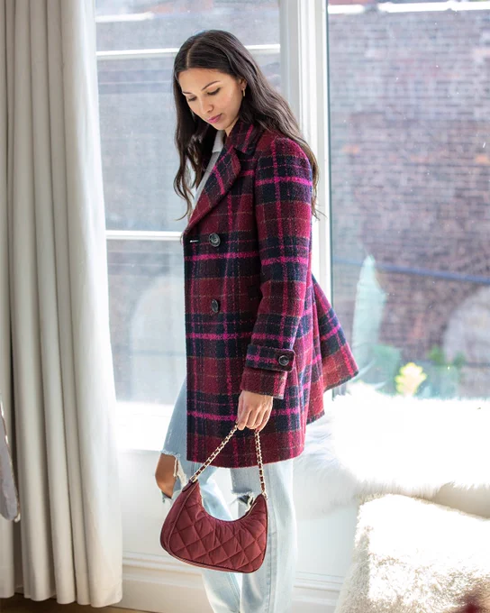 Two images that show how to style a double breasted peacoat in a pink oversize check print. A pink dress and jeans and button down are shown with the jacket.