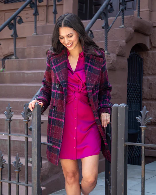 Two images that show how to style a double breasted peacoat in a pink oversize check print. A pink dress and jeans and button down are shown with the jacket.