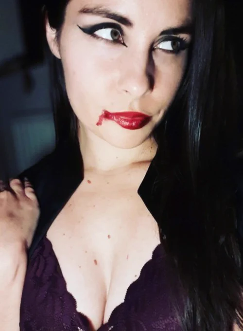 photo of turtletickles in a vampire-inspired cosplay with fake blood on her mouth