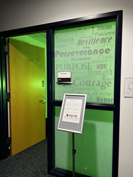 The Library's Quiet Space resonates with green light; window art lists words such as resilience, perseverance, hope, strength, courage, etc. 
