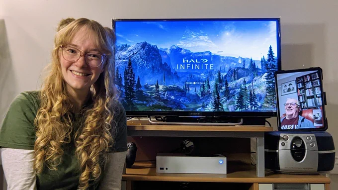 I smile next to the halo infinite splash screen. My dad smiles on a tablet device.