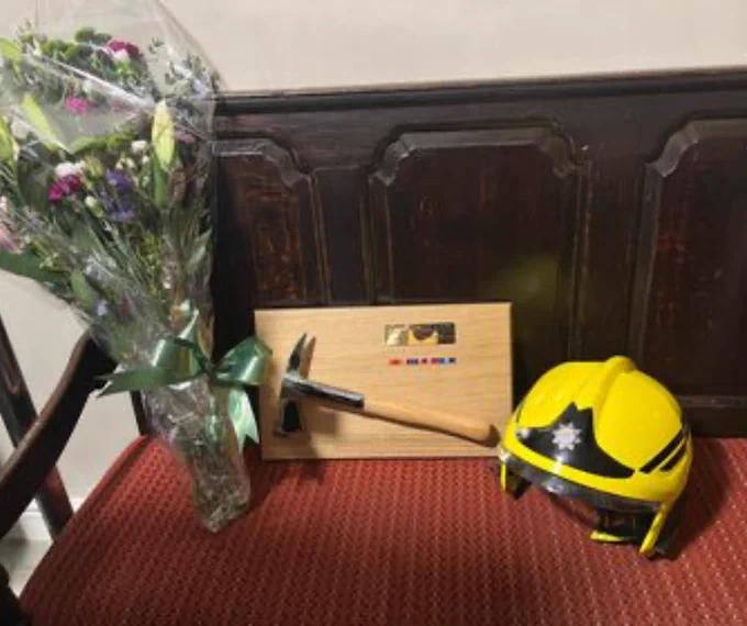 Fire helmet, flowers, and plaque