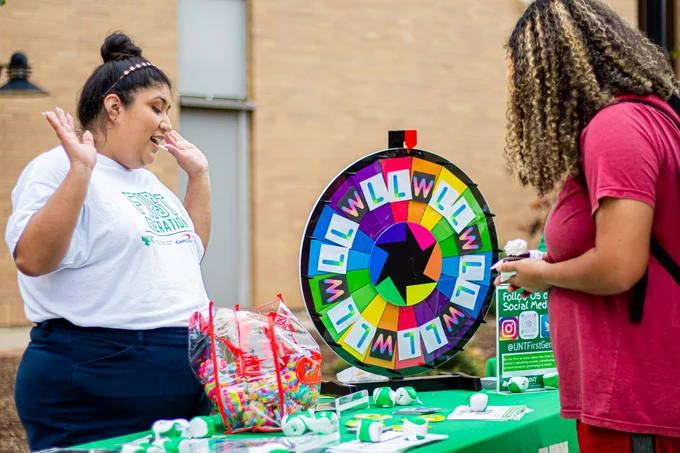 staff and student at table with colorful spinning wheel