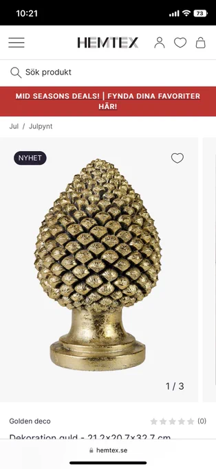 En julprydnad i form av en tallkotte i mässing, men den står uppochnervänd med en bas för att påminna om en julgran vilket gör att den mest ser ut som en butt-plug.